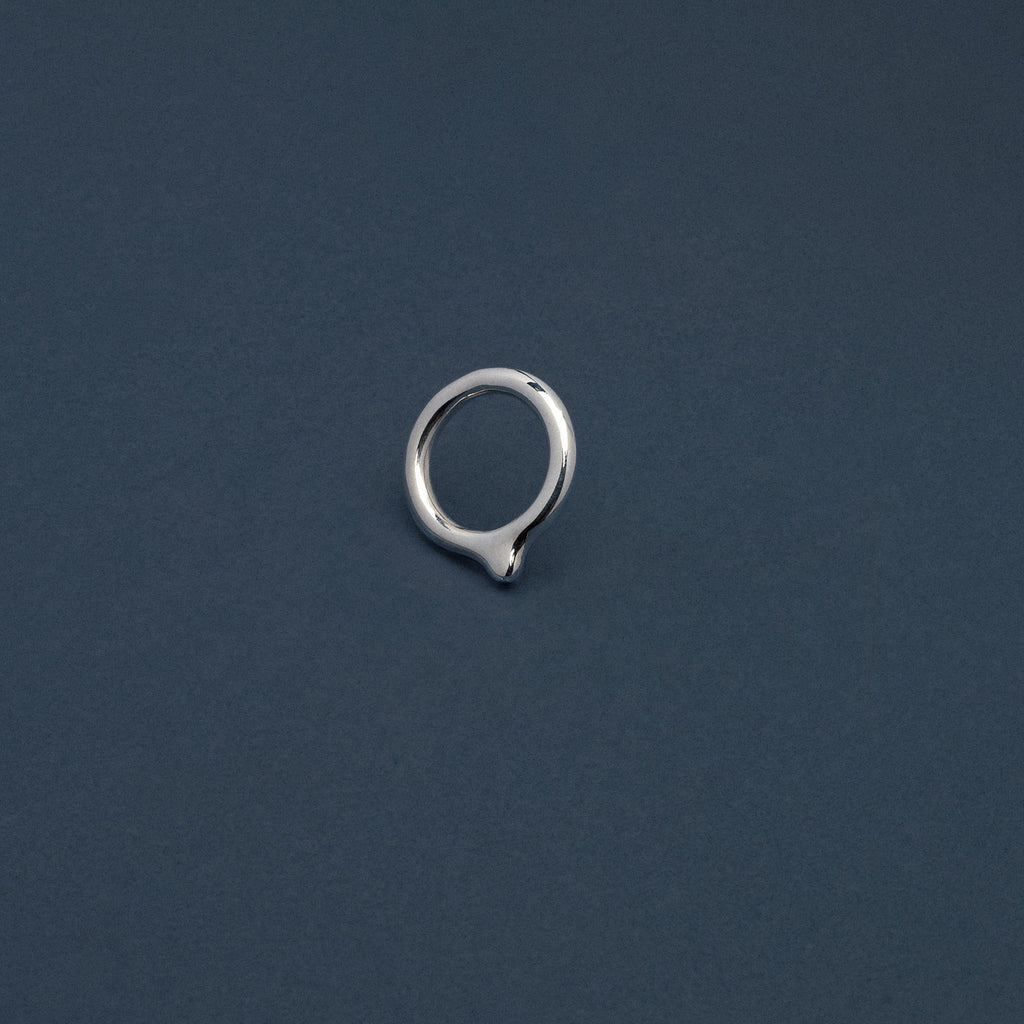 Silver earring on a dark blue background