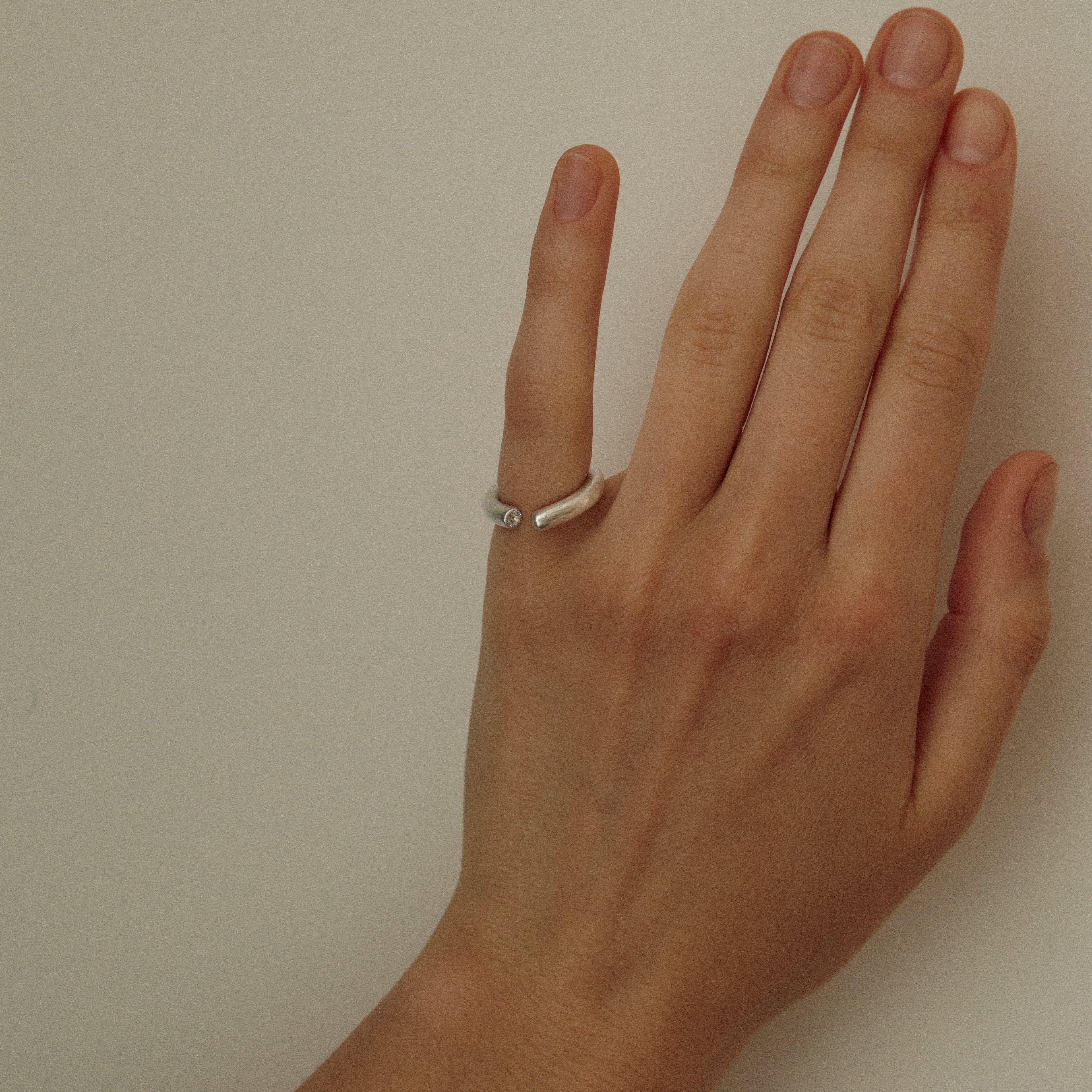 Hand with a ring on a plain background