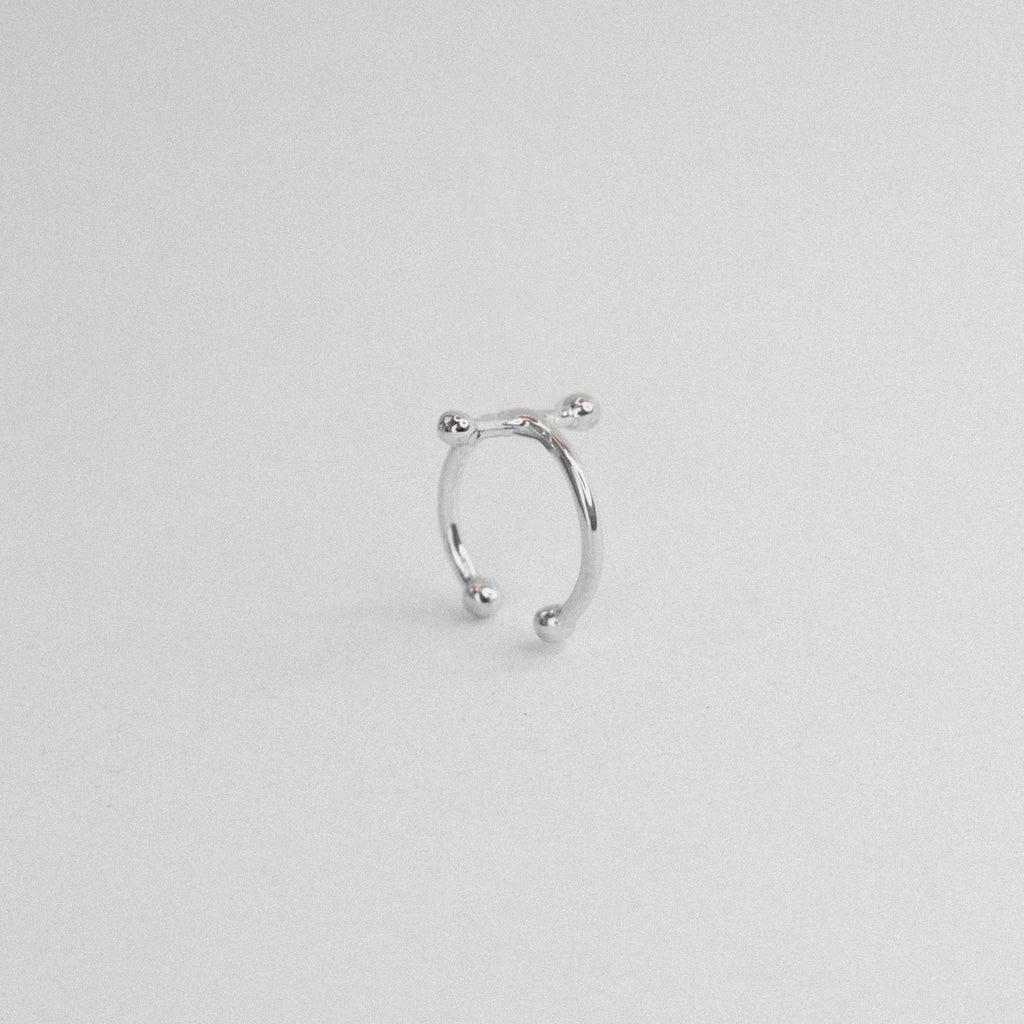 Silver nose ring on a light gray background
