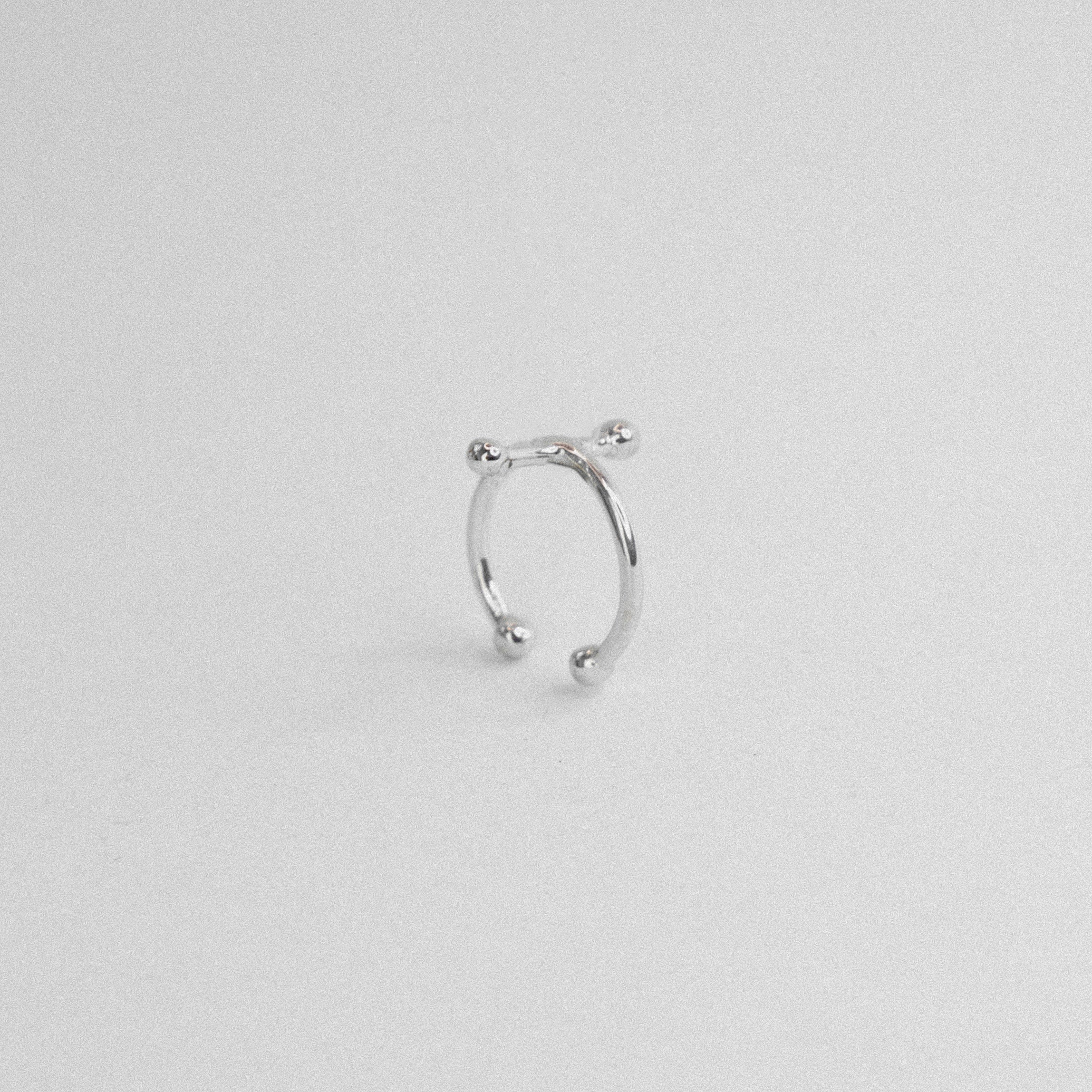 Silver nose ring on a light gray background