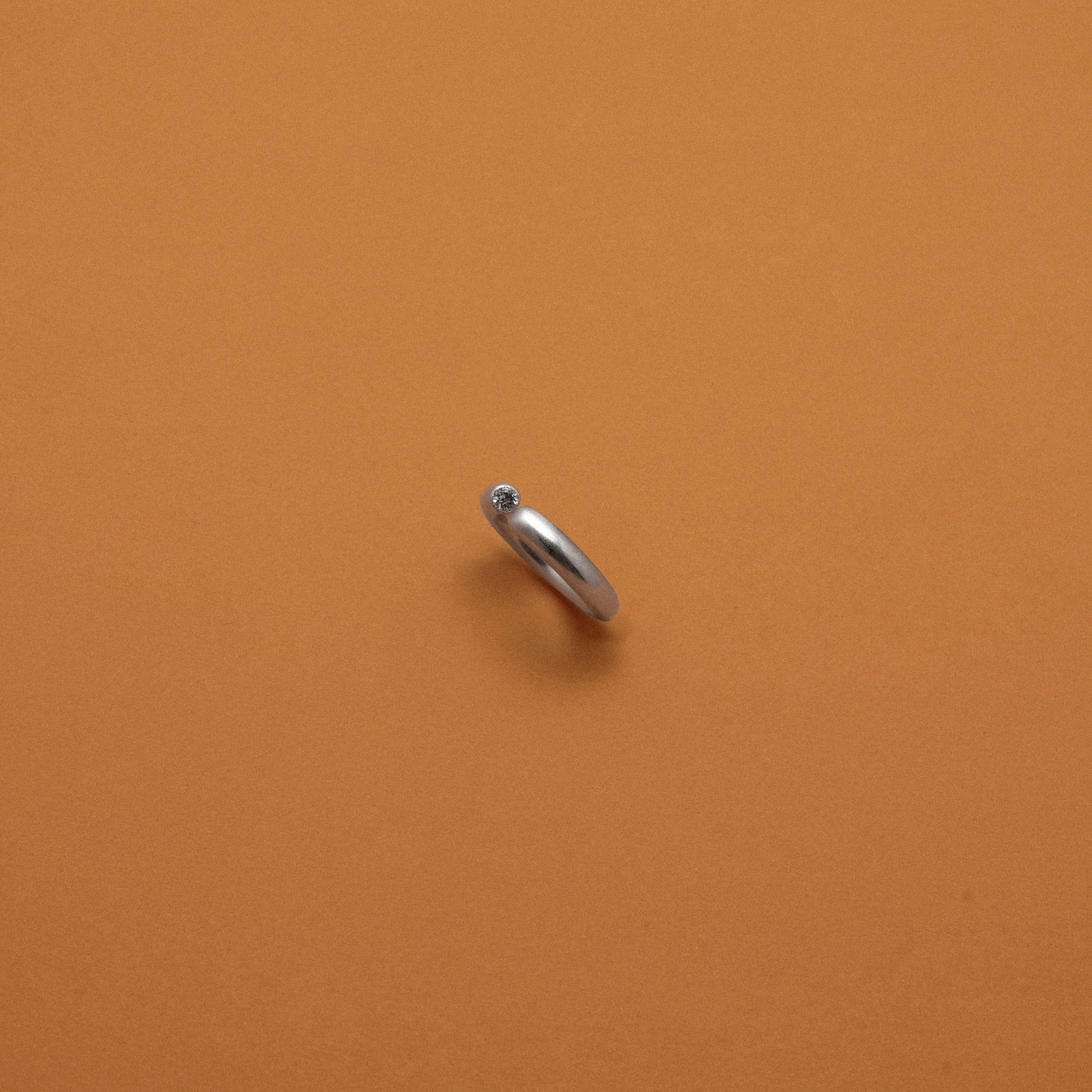 Silver ring on an orange background